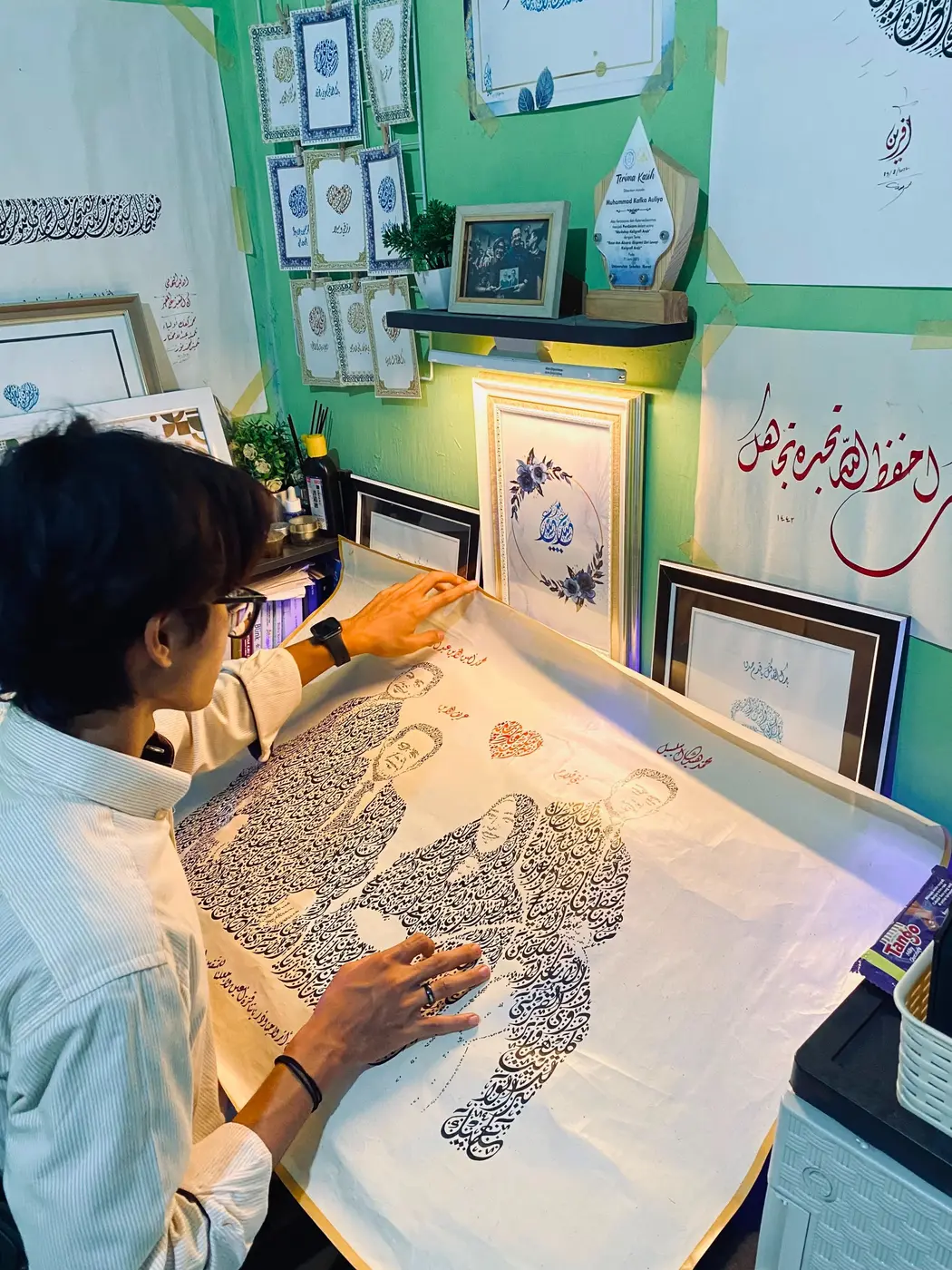 Artist Silka Arts menyiapkan karya siluet kaligrafi sebelum proses order selesai