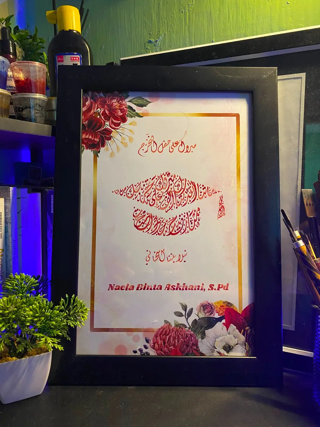 Kaligrafi wisuda berbentuk toga dengan tinta merah
